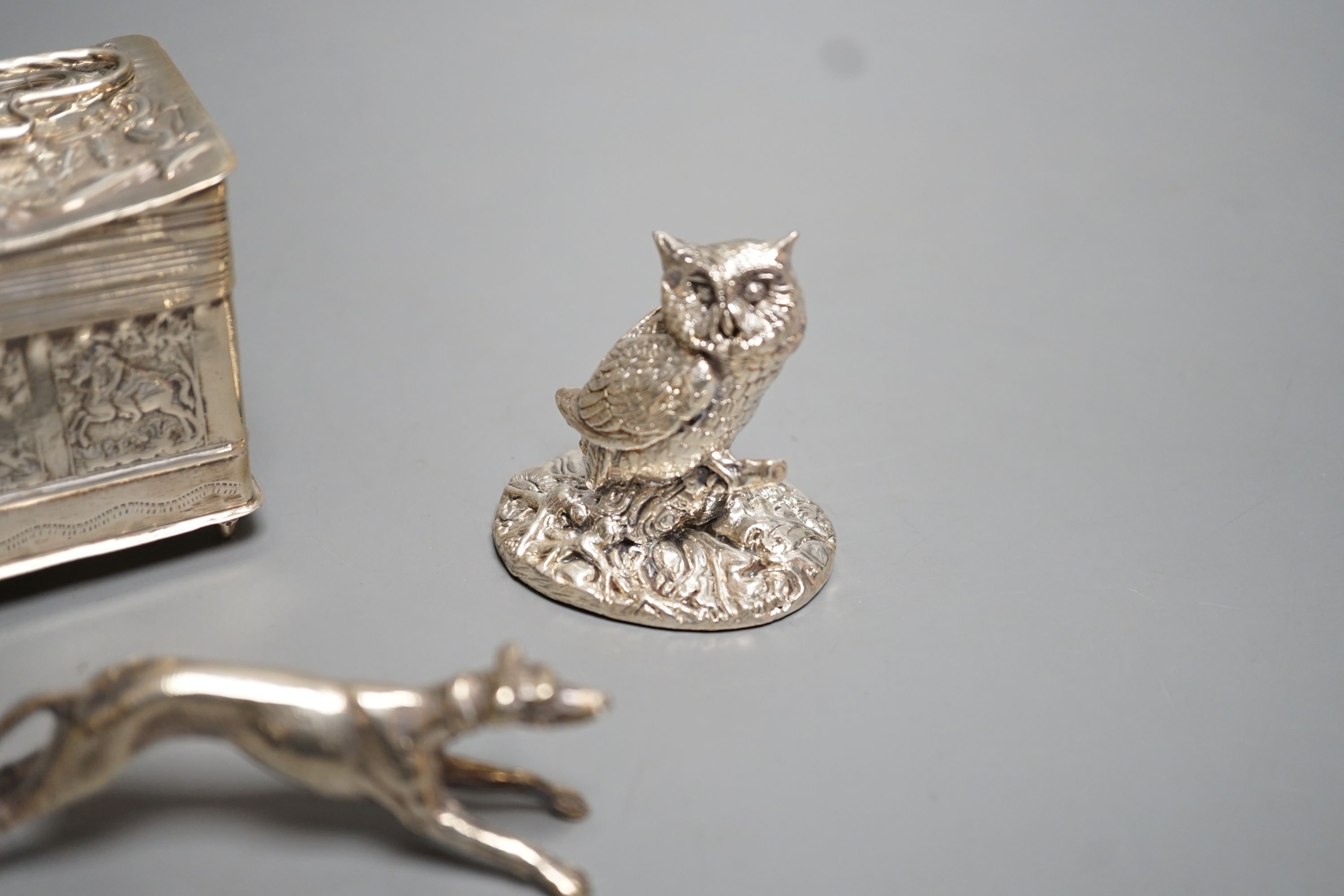 A continental embossed silver box, with import marks for London, 1903, 65mm, a modern silver filled model owl and a metal model of a dog.